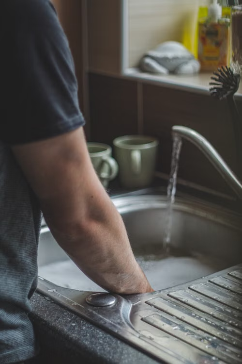 A kitchen sink with water pooling due to a clogged drain.