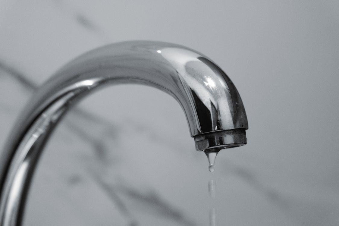 Bathroom faucet dripping water due to a plumbing leak.