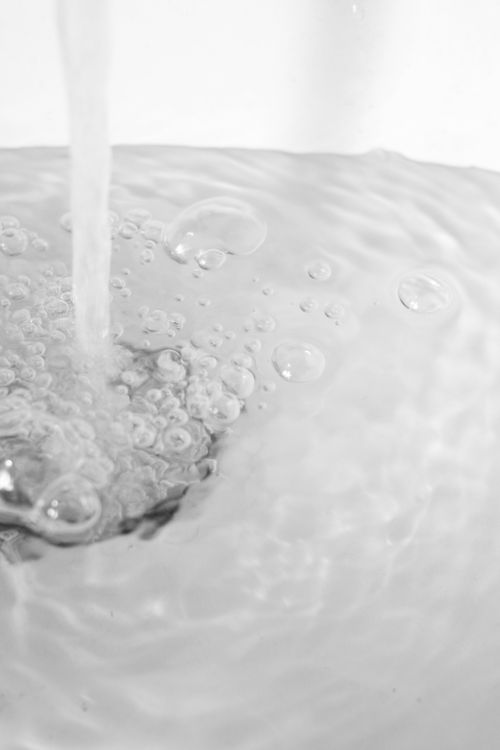 Water flowing into a kitchen sink during normal household use.